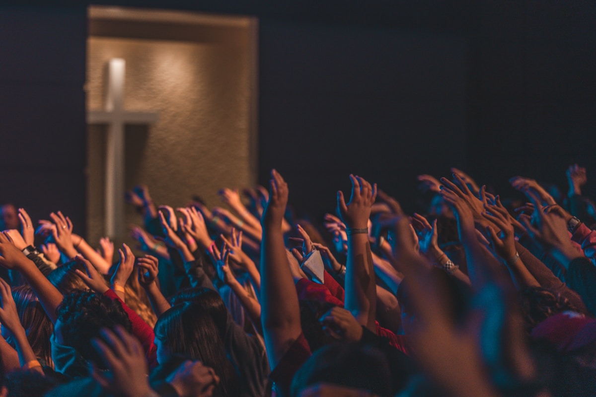 A worship community gathered with hands raised